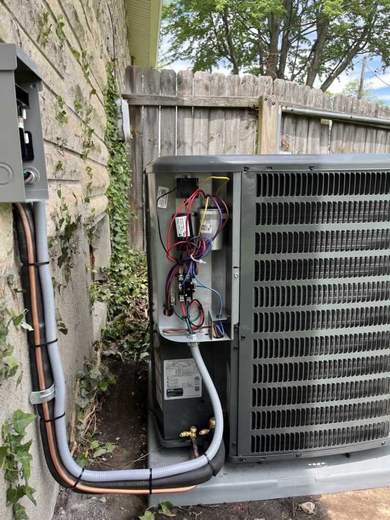 Open AC condenser control panel showing clean wiring and a new capacitor after repair in Louisville, KY