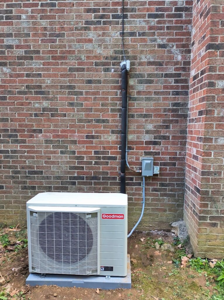 Goodman AC condenser with a neatly run line set on a brick home in Louisville, KY
