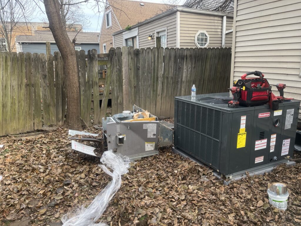 New Goodman packaged HVAC unit set in place next to the old unit during a full system replacement in Louisville, KY