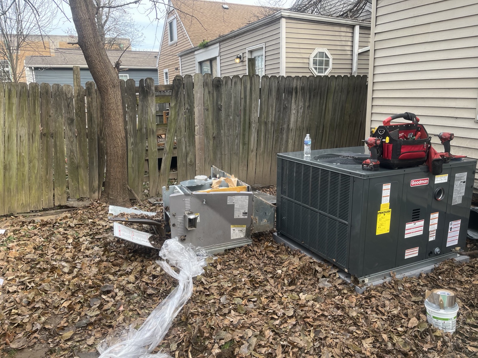 New Goodman packaged HVAC unit set in place next to the old unit during a full system replacement in Louisville, KY